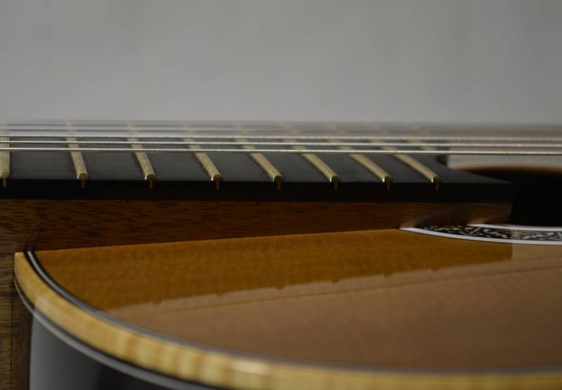 The top is sloped down and the neck angle slightly increased to increase response and facilitate playing above the 12th fret